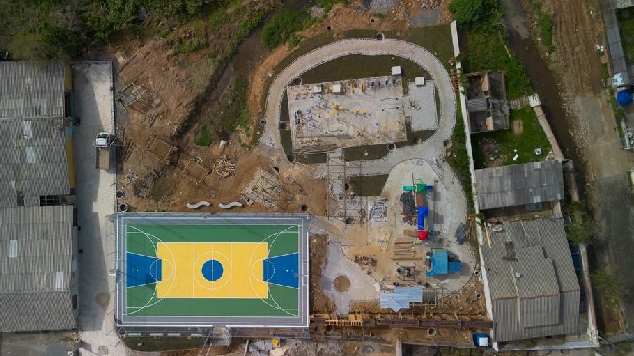 Praça pública em Campo Largo vista de cima durante a obra, com a quadra pronta e o restante do terreno em execução