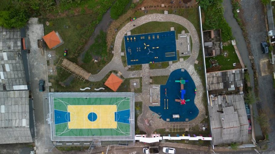 A mesma praça pública vista de cima na entrega, com playground, academia ao ar livre e caminhos concluídos